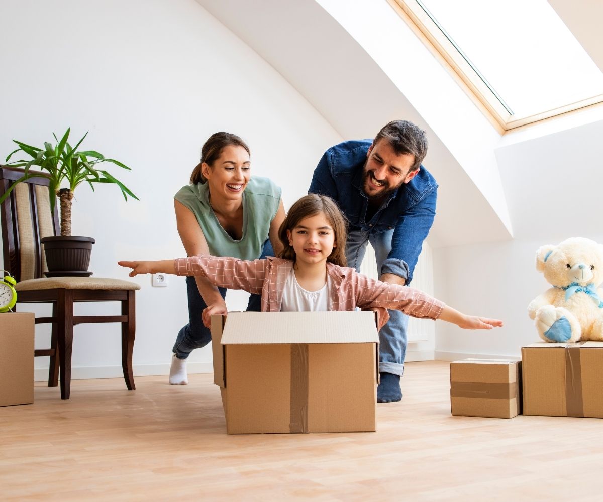 Woman and man pushing girl in box