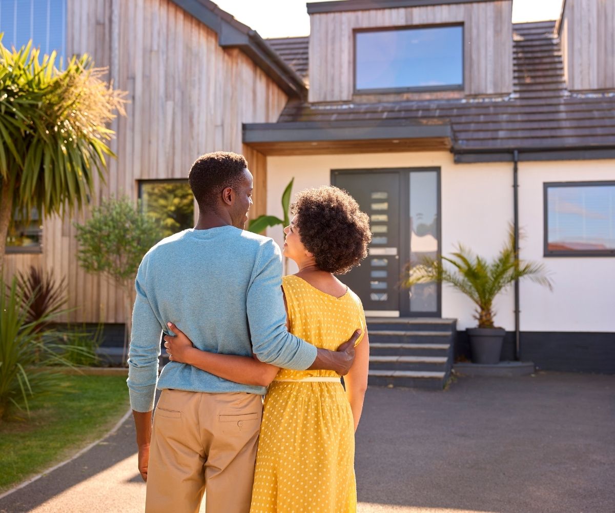 Couple standing outside of house