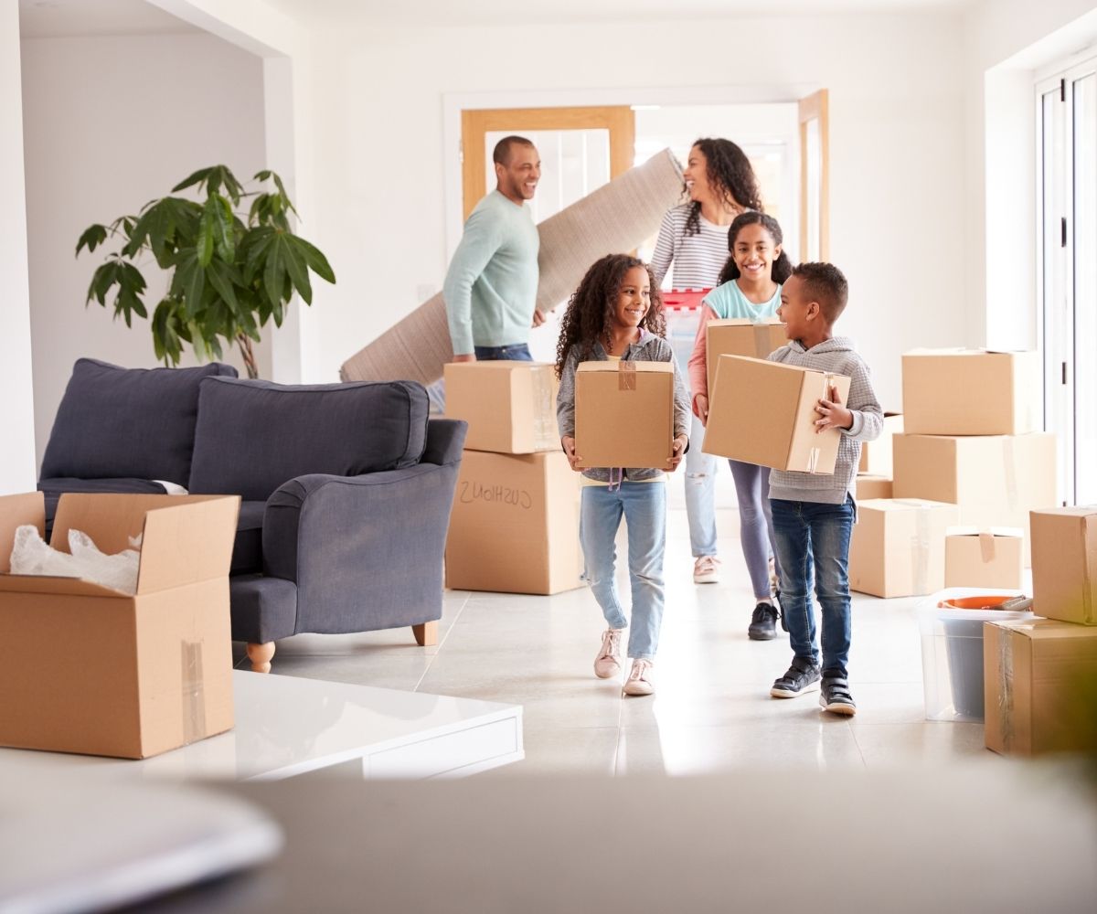 Family carrying moving boxes
