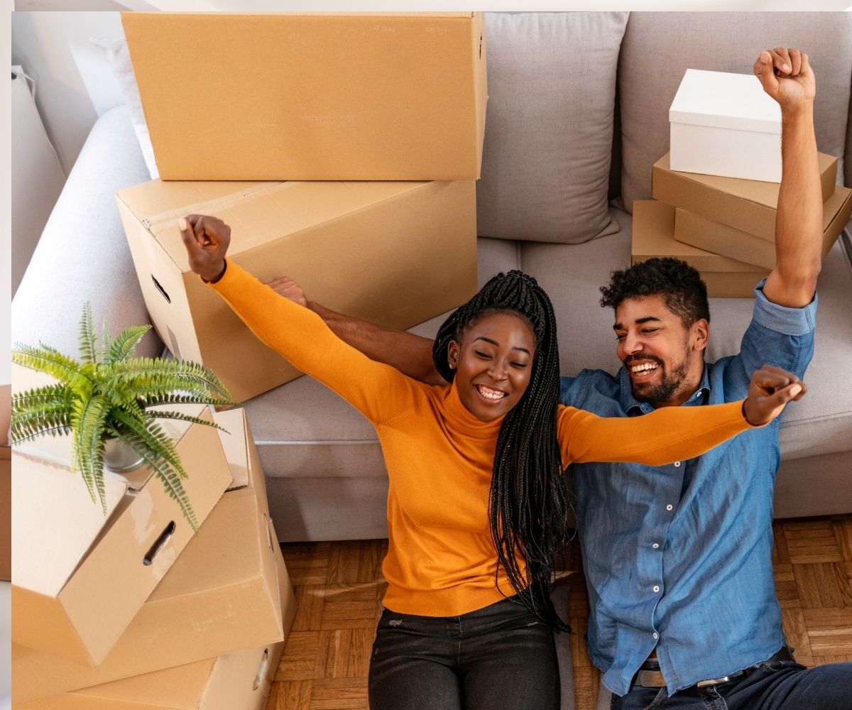 Man and woman cheering with moving boxes