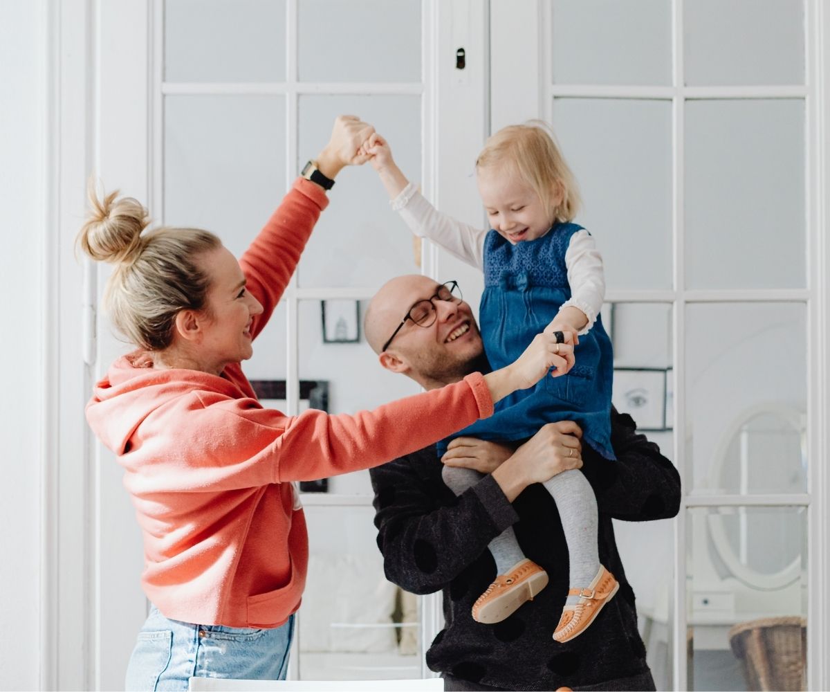 Man holding daughter with wife