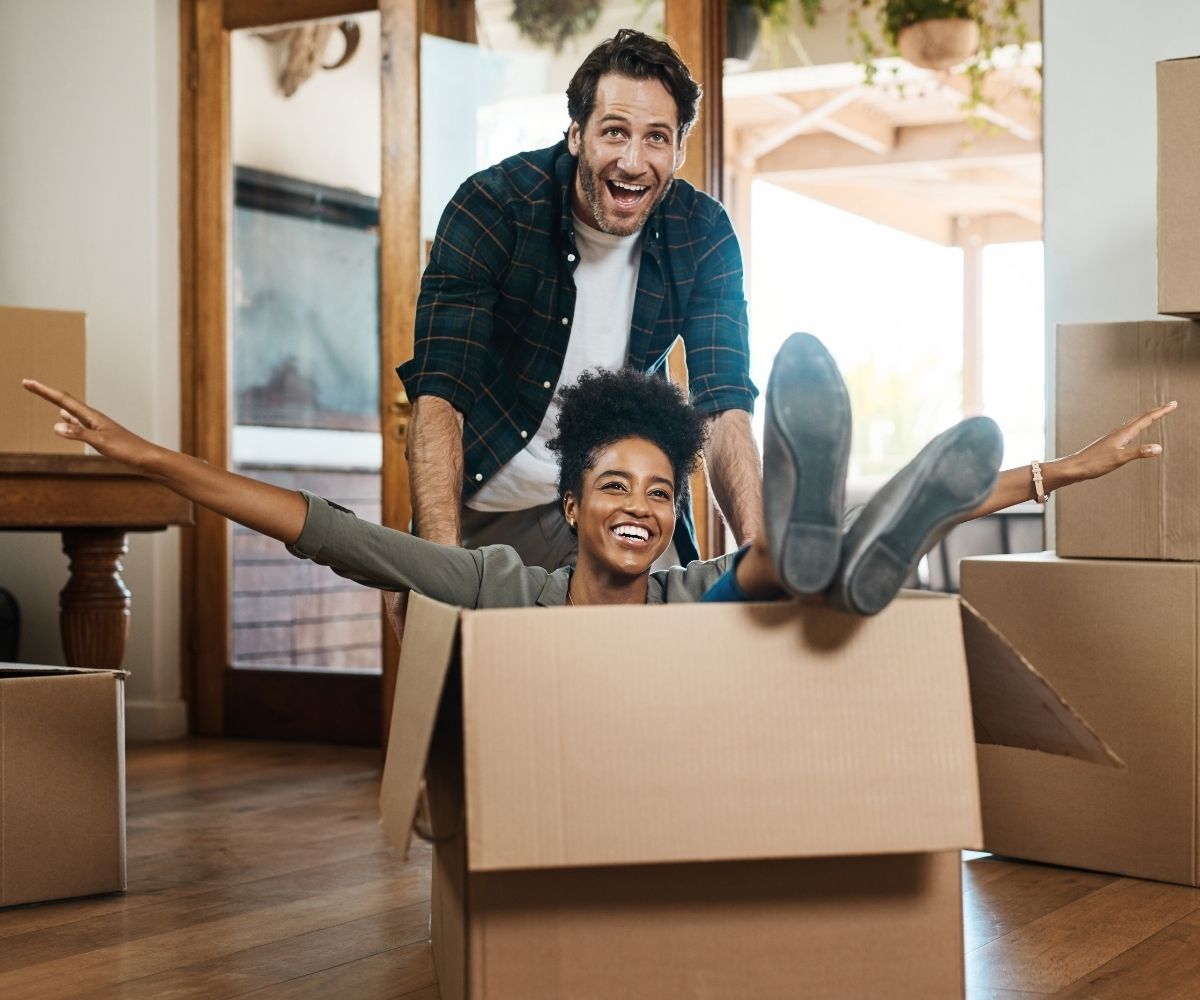 Man pushing woman in moving box Man pushing woman in moving box