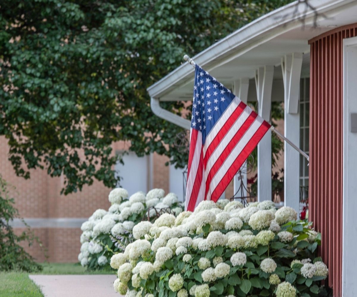 American flag on house with flowers