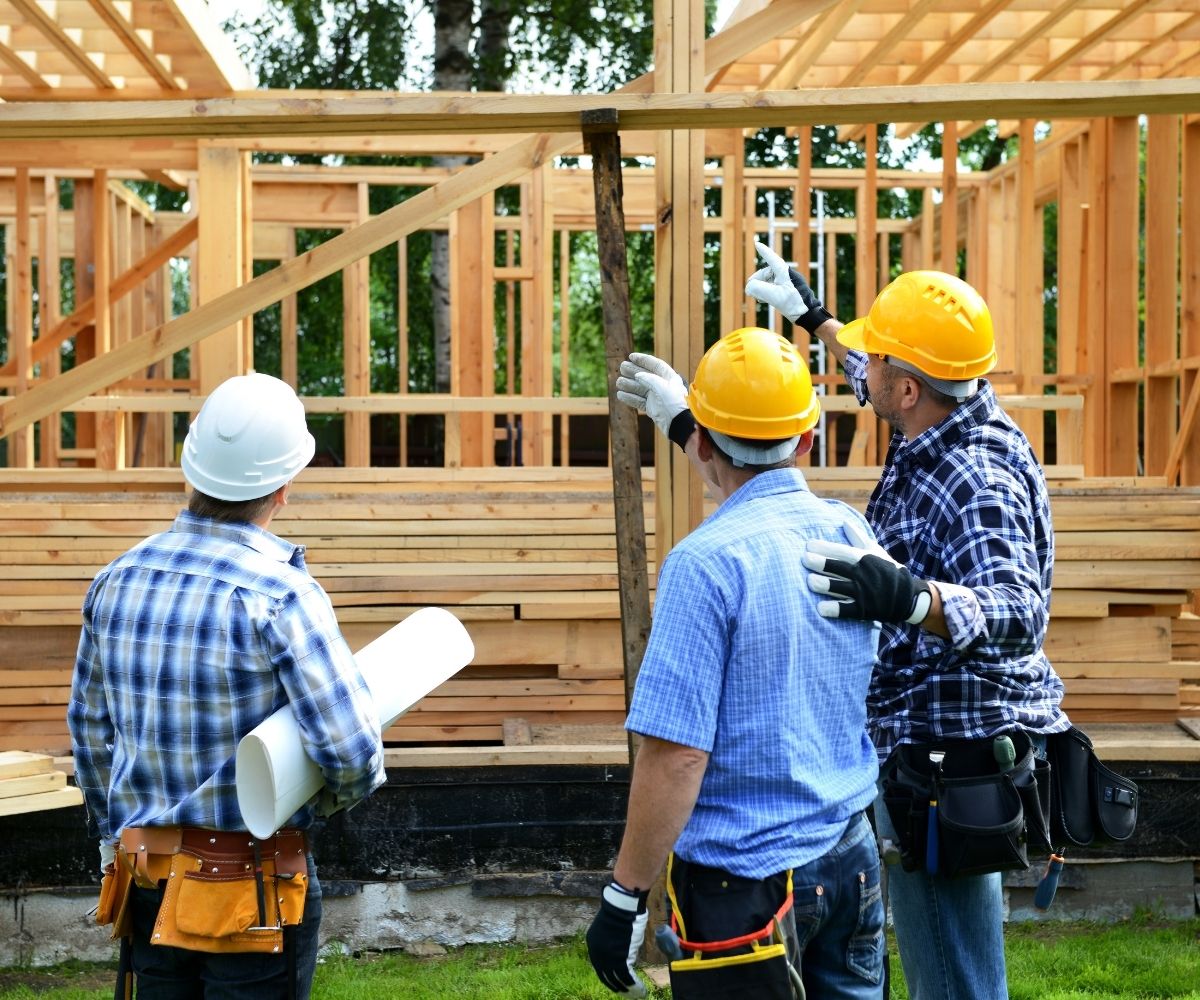 Builders looking at home being built