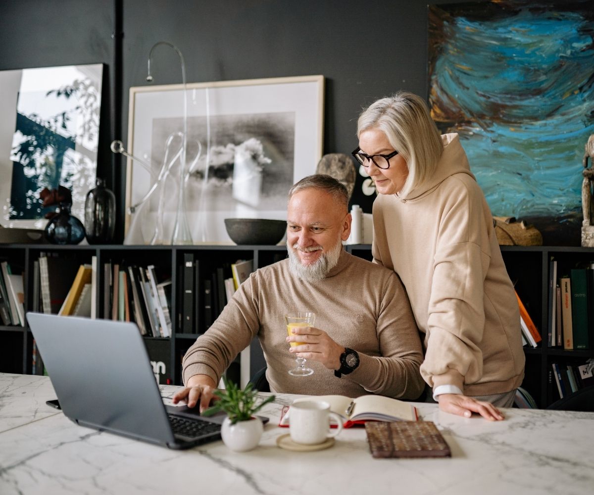 Man and woman at table using laptop