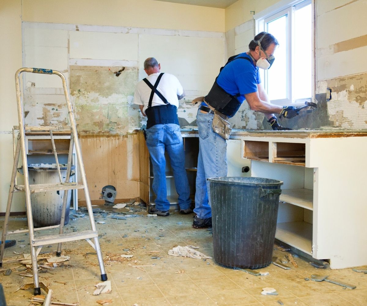 Two men demoing a kitchen