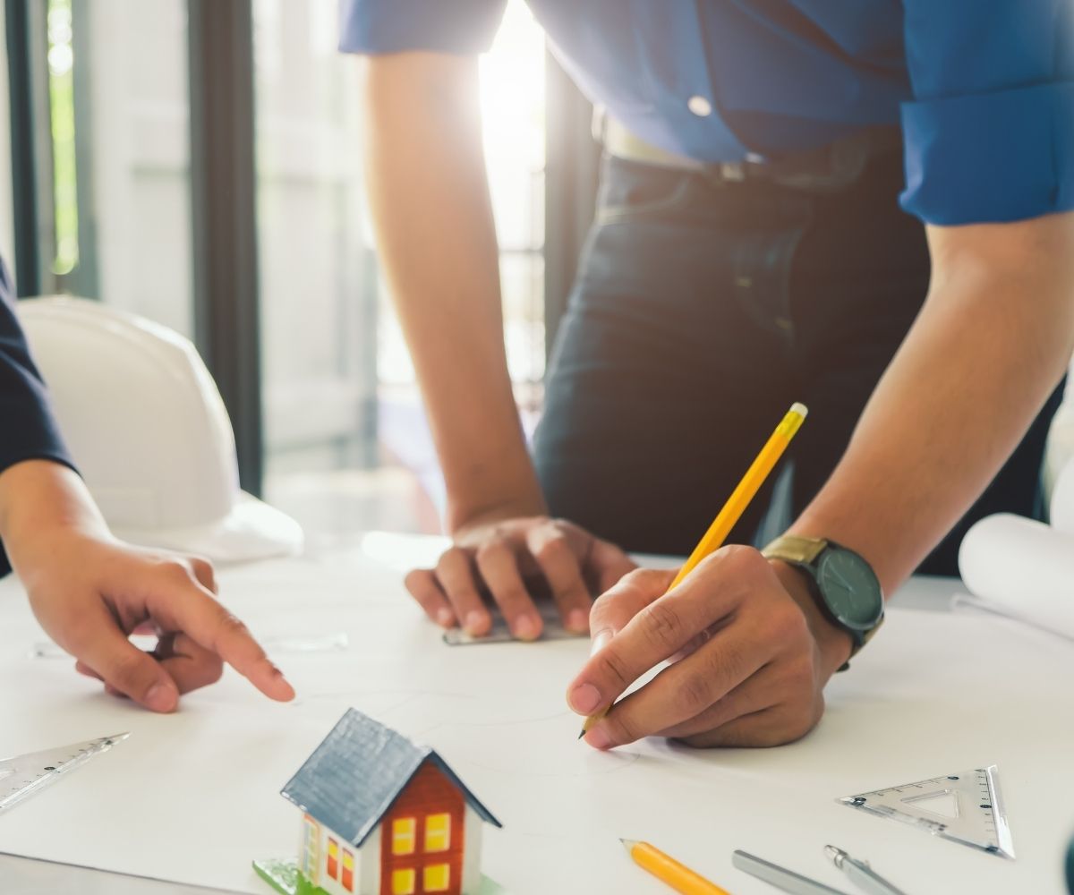 Two people drawing out house blueprint